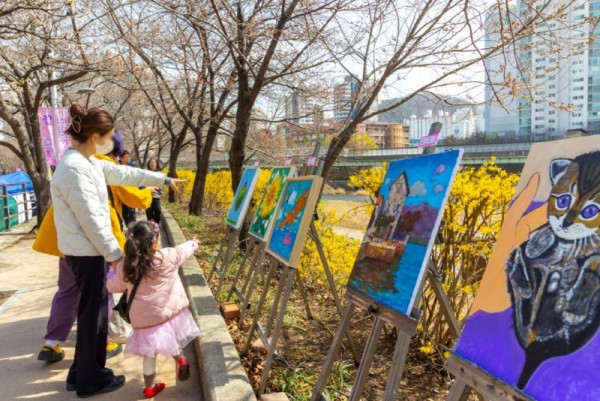 사진4) 시민들이 30일 2024 안양충훈벚꽃축제 산책길에서 소울음아트센터 전시 작품을 자연과 함께 즐기고 있다.JPG